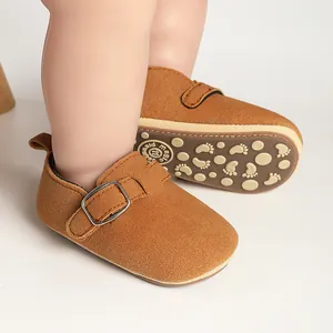 Close-up of retro brown frosted baby shoes with anti-slip footprint pattern sole.