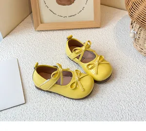 Detailed view of yellow children's Mary Jane princess shoes featuring dual bow accents