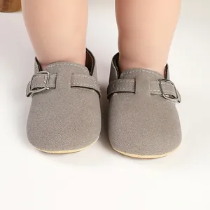 Close-up detail of vintage grey frosted suede baby shoes with an adjustable buckle strap