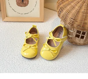 Close-up of yellow girls' patent leather Mary Jane shoes featuring double bow details.