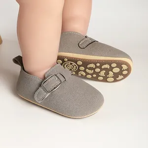 Close-up of baby matte suede Birkenstock shoes with adjustable buckle and patterned sole