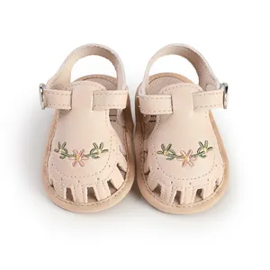 Dettaglio dei sandali beige per neonata con ricami floreali e fori traspiranti.