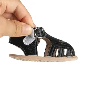 Dettaglio sandalo estivo nero per neonata con chiusura a velcro e suola morbida.