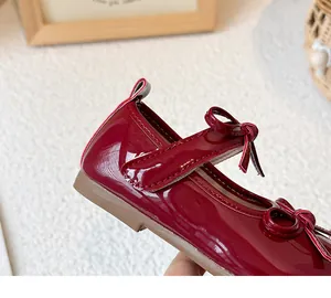 Macro view of red patent leather girl's shoe showing stitching and bow detail quality