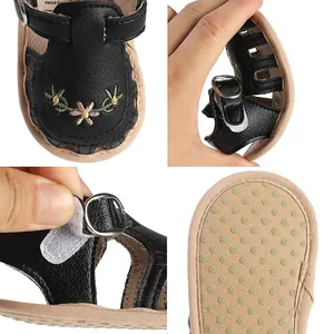 Dettagli di sandali neri per neonata con ricami floreali, suola flessibile e velcro