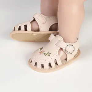 Vista dettagliata di sandali beige per neonata con ricami floreali e suola antiscivolo
