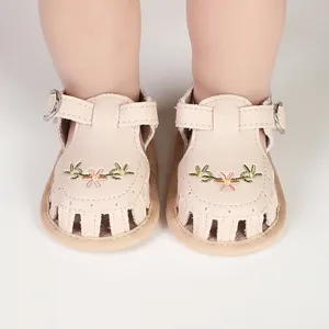 Vista detallada de las sandalias beige para bebé con bordado floral y tira en T