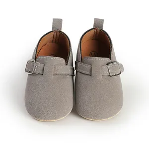 Detailed top-down view of grey faux-suede baby shoes with buckle and soft lining