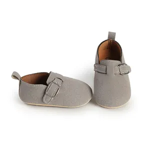 Detail view of grey faux suede baby monk strap shoes with adjustable metal buckle.