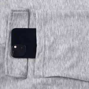 Macro view of pocket on heavyweight grey cargo sweatpants with smartphone inside