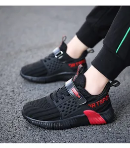 Detail eines schwarzen Jungen-Laufschuhs mit atmungsaktivem Mesh und roten Akzenten