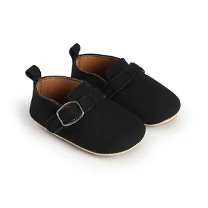 Detail view of retro black matte suede baby buckle strap shoes on white background