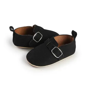 Detailed view of black suede retro baby shoes with a silver buckle strap and flat sole