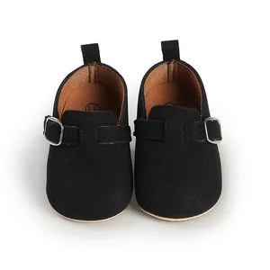 Close-up of black matte monk strap baby shoes with elegant silver buckles