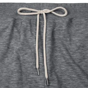 Detailed view of the drawstring waistband on grey heavy cotton joggers with metal aglets.