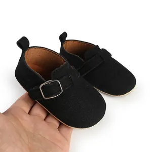 Close-up of vintage black matte baby shoes with adjustable silver buckle detail
