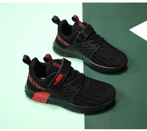 Detail von atmungsaktiven schwarz-roten Mesh-Laufschuhen für Jungen mit Klettverschluss
