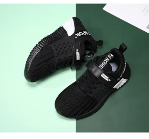 Detailansicht des atmungsaktiven Mesh-Gewebes und des Klettverschlusses schwarzer Jungenschuhe