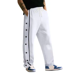 Vista detallada de botones de presión y rayas laterales negras en pantalones hip-hop blancos