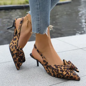 Detailed view of leopard print pointed-toe kitten heels with elegant bow accent.