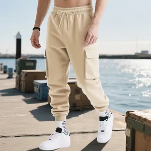 Detailed view of men's beige heavy cargo sweatpants with drawstring waist and pockets