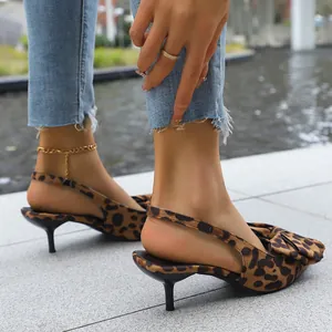 Close-up of leopard print slingback sandals with kitten heel and bow detail on the side