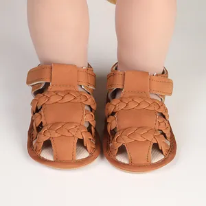 Primer plano de sandalias trenzadas marrones para bebé con cierre de velcro para el verano.