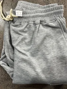 Detail shot of grey men's joggers showing size L tag and 100% polyester material.