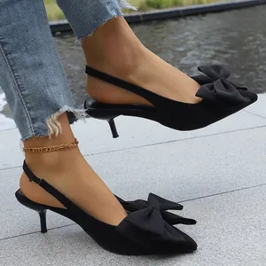 Close-up of black pointed-toe kitten heel sandals with large bow detail and slingback strap