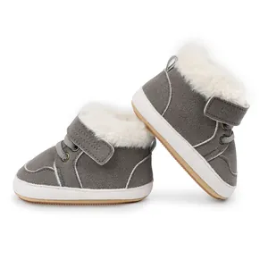 Detalle de botas de invierno grises para bebé con forro de pelo blanco y suela blanda