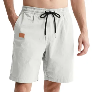 Detail view of white men's casual beach shorts featuring a black drawstring
