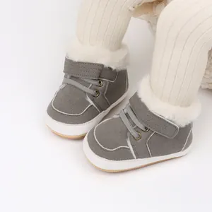 Primer plano de zapatos de bebé grises con forro de piel blanca y cierre de velcro
