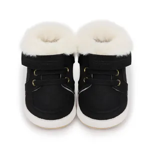 Vista frontal de botas de invierno negras para bebé con suave forro de piel blanca