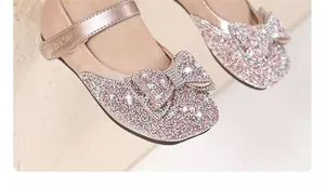 Close-up of pink rhinestone princess shoes with bow for girls