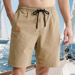 Premium detail view of men's khaki drawstring summer shorts in a sailing yacht setting.