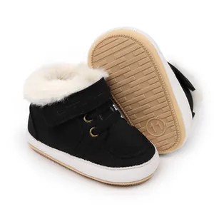 Primer plano de botas de invierno negras para bebé con forro de piel sintética blanca y gruesa