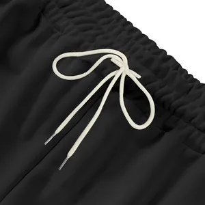 Primer plano del cordón blanco ajustable y la cintura elástica de un pantalón de chándal negro