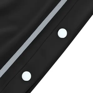 Detalle de botones a presión blancos en pantalones de chándal de baloncesto negros modernos.