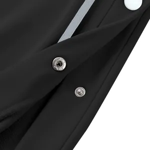 Primer plano del detalle del botón lateral en pantalones deportivos negros pesados