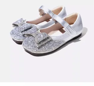 Close-up detail of silver glitter girls Mary Jane shoes featuring a decorative bow