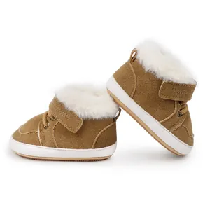 Primer plano de botas de invierno marrones para bebé con forro de piel sintética blanca gruesa