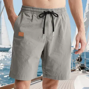 Close-up view of men's grey casual beach shorts featuring a black drawstring waist