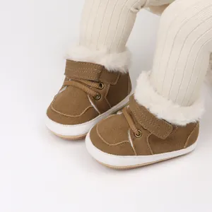 Detalle de zapatos cálidos para bebé en marrón con forro de pelo sintético y suela blanda.
