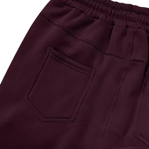 Primer plano del bolsillo trasero y la cintura elástica de un pantalón de chándal burdeos pesado.