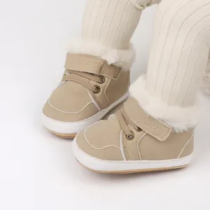 Primer plano de botas de invierno para bebé forradas de felpa beige con suela blanda