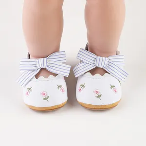 Vista dettagliata delle scarpe da principessa per neonata con ricami floreali e fiocco