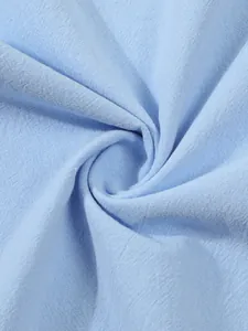 Close-up of light blue cotton linen fabric showing detailed weave and soft texture.