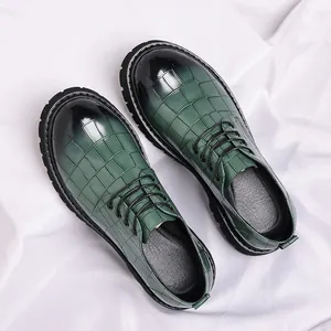Detailweergave van groene herenleren schoenen met krokodillenpatroon en verloop