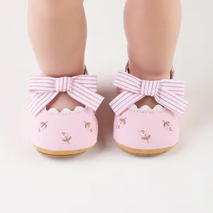 Dettaglio scarpe da principessa rosa per neonata con ricami floreali e fiocco
