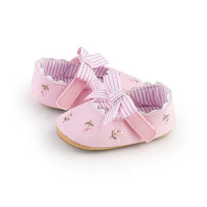 Vista dettagliata di scarpe da principessa rosa per neonata con ricami e fiocco a righe